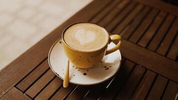 Hot coffee latte with latte art milk foam in cup mug on wood desk in a coffee shop at the cafe video