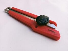 Close up horizontal shot of red cutting tool, white background photo