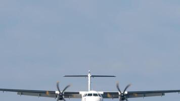 Turboprop aircraft with an unrecognizable livery approaching landing, middle shot. Airplane descending. Travel concept. Spotting video