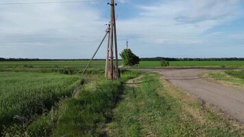 A view of a rural road with power lines and green fields in the summer video