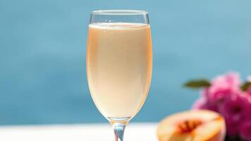 Champagne Glass on White Table with Peach and Pink Flowers in Background photo