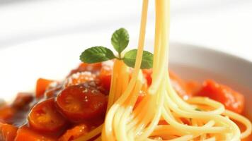 Close-up of spaghetti with tomato sauce and a sprig of basil photo