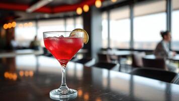 Red Cocktail with Lime Garnish on a Bar Table photo