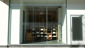 Modern storefront with glass windows and a wooden shelf display photo