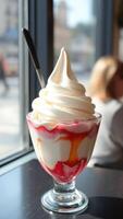 Closeup of a Delicious Soft Serve Ice Cream Sundae with Red and Yellow Drizzle photo