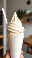Closeup of a Vanilla Soft Serve Ice Cream Cone in a Hand photo