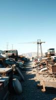 A junkyard with a crane and a mountain in the background photo
