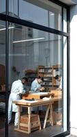 Three people working at a table in a workshop photo