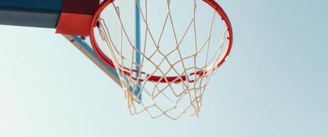 Close up of a basketball hoop net with a clear blue sky in the background photo