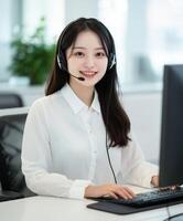 Smiling Female Customer Service Staff Working at Computer with Headset in Office photo