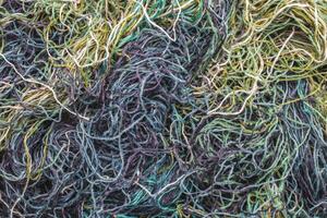 background of colored threads chaotically intertwined. green yellow and brown threads matted in a colorful background photo