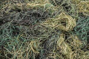 background of colored threads chaotically intertwined. green yellow and brown threads matted in a colorful background photo