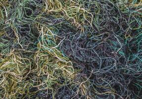 background of colored threads chaotically intertwined. green yellow and brown threads matted in a colorful background photo