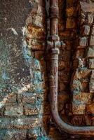 Old rusty water pipe in a brick wall. Old rusty pipe with valves on painted brick wall with rectangle recess. Urban build texture photo