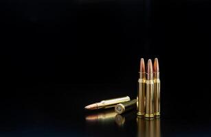 Bullet isolated on black background with reflexion. Rifle bullets close-up on black back. Cartridges for rifle and carbine on a black. photo