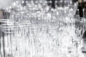 Lots of different empty glasses on the table. Preparing for a banquet, holiday or wedding. Blurred back. photo
