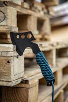 A small black ax with a paracord-wrapped handle. A tool for cutting branches or firewood in the forest. Self defense weapon. Wooden back. photo