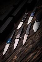 Folding knives on a wooden background. Pen knives on a dark brown back. photo