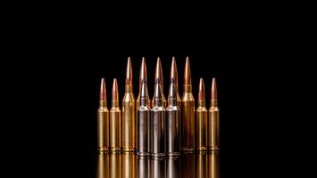 Bullet isolated on black background with reflexion. Rifle bullets close-up on black back. Cartridges for rifle and carbine on a black. photo