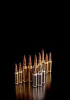 Bullet isolated on black background with reflexion. Rifle bullets close-up on black back. Cartridges for rifle and carbine on a black. photo