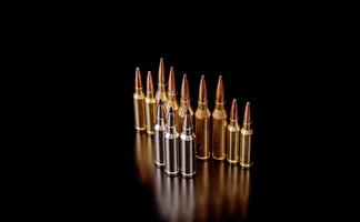 Bullet isolated on black background with reflexion. Rifle bullets close-up on black back. Cartridges for rifle and carbine on a black. photo