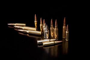 Bullet isolated on black background with reflexion. Rifle bullets close-up on black back. Cartridges for rifle and carbine on a black. photo
