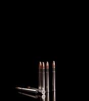 Bullet isolated on black background with reflexion. Rifle bullets close-up on black back. Cartridges for rifle and carbine on a black. photo