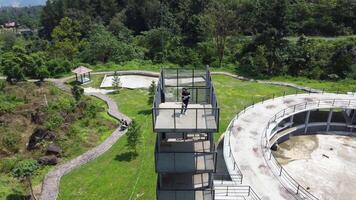 A man is standing on a platform in the middle of a park video