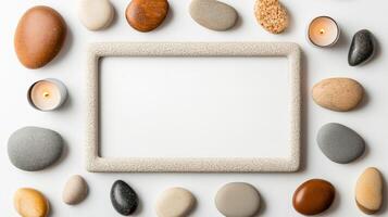 Overhead view of a meditation themed picture frame with a border of zen stones tranquil water reflections and soft candlelight in calming neutral colors isolated on a white background photo