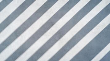 Overhead view of a plain concrete wall surface with soft shadow details and subtle texture light gray with a polished clean finish ideal for neutral backgrounds photo