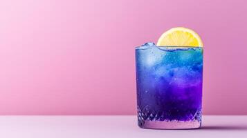 Exotic cocktail with butterfly pea flower tea, gin, and lemon, shifting from deep blue to vibrant purple in a glass, served against a gradient background fading from indigo to soft lavender photo