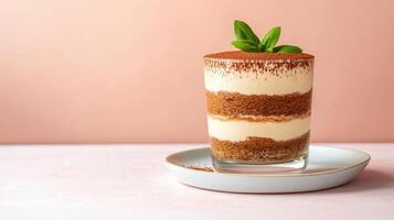 Exquisite dessert of layered tiramisu in a glass, dusted with cocoa powder, placed on a white plate with clear empty space for text, warm gradient background photo