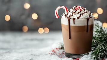 Frosty peppermint mocha with candy cane garnish, whipped cream, and chocolate drizzle, placed on a snowy table with frosted evergreen branches and soft winter bokeh in the background photo
