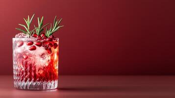 Spiced pomegranate cocktail with gin and tonic, garnished with fresh pomegranate seeds and rosemary, rich colors against a gradient background from dark red to soft gold photo