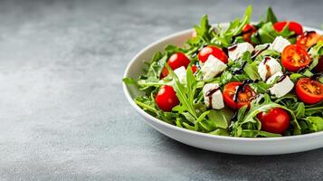 Vibrant salad with mixed greens, cherry tomatoes, feta cheese, and balsamic glaze, plated on a round white dish with clear empty space for text, soft gradient background photo