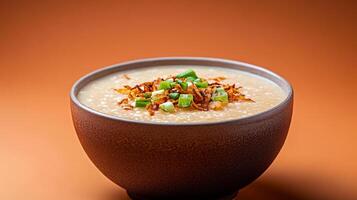 Warm autumn Asian dish featuring a bowl of savory pumpkin congee, topped with crispy shallots and fresh green onions, set against a gradient background shifting from burnt orange to deep brown photo