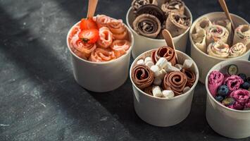 rolled ice creams in cone cups on dark background photo