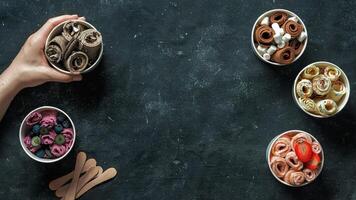 rolled ice creams in cone cups on dark background photo