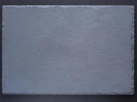 Empty black slate board for serving on dark background. Flat lay or top view. Can use fo design menu photo