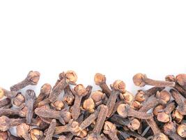 Cloves spice on white background with copy space. Isolated one edge. Top view or flat lay. photo