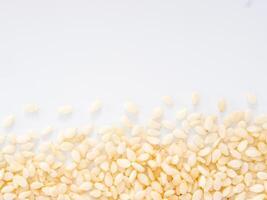 Sesame Seeds on white background with copy space. Isolated one edge. Top view or flat lay. photo