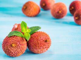lichee fruit on turquoise wooden background close up photo