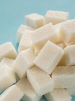 Background of sugar cubes. White cube sugar on blue background. White sugar close up photo