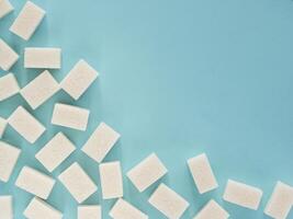 background of sugar cubes. White cube sugar on blue background. White sugar close up with copy space photo
