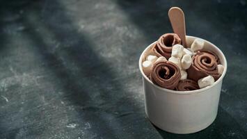 Rolled ice cream in cone cup on dark,copy space photo