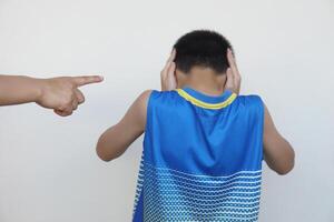 Closeup finger point to boy who coverd ears with his hand. Concept, disobey, naughty , negative behaviour. Blame punishment scold. Don't want to listen complain. Bullying. photo
