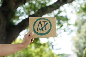 Close up hand holds paper card with drawn sign AI in circle and tick mark. Concept, Choose ,agree and accept to use AI or Artificial Intelligence to apply in daily life. photo