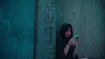Youth in Hoodie Using Phone in Dimly Lit Space video