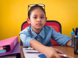 Cute girl working on the desk with document isolated yellow background. Concept of achievement. photo