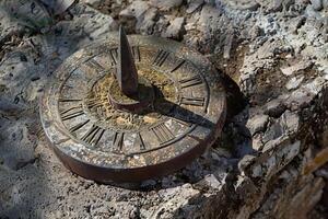 Ancient sundial casting shadow on stone surface telling time photo